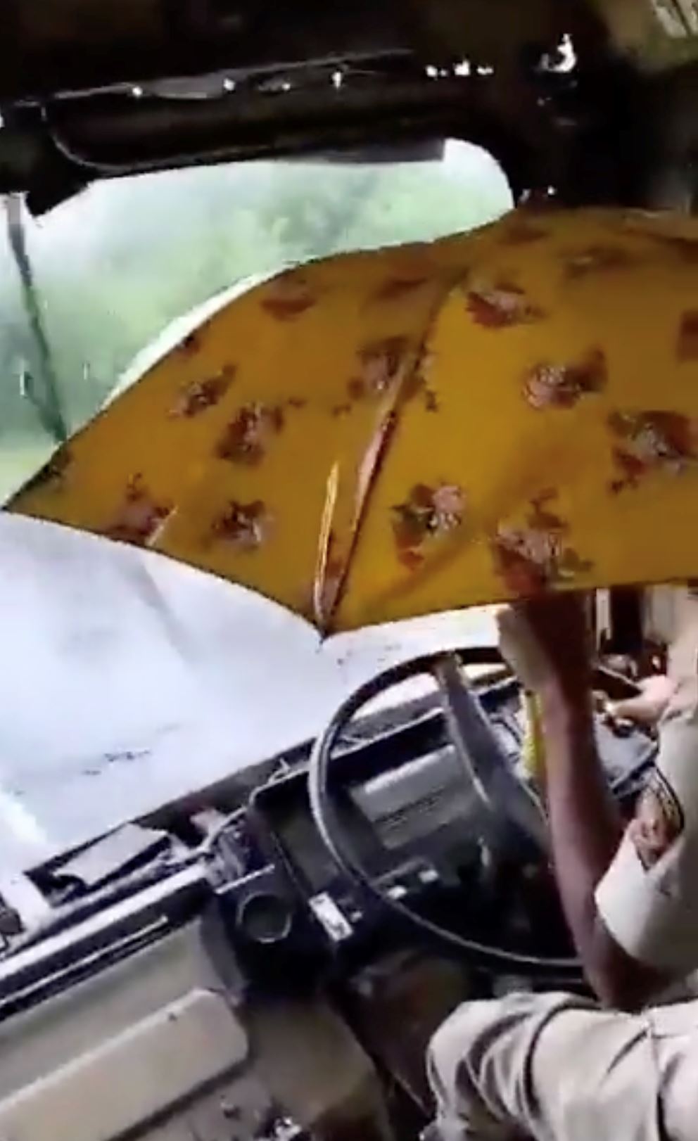 bumbung bas bocor, pemandu terpaksa drive pegang payung sebelah tangan [video]