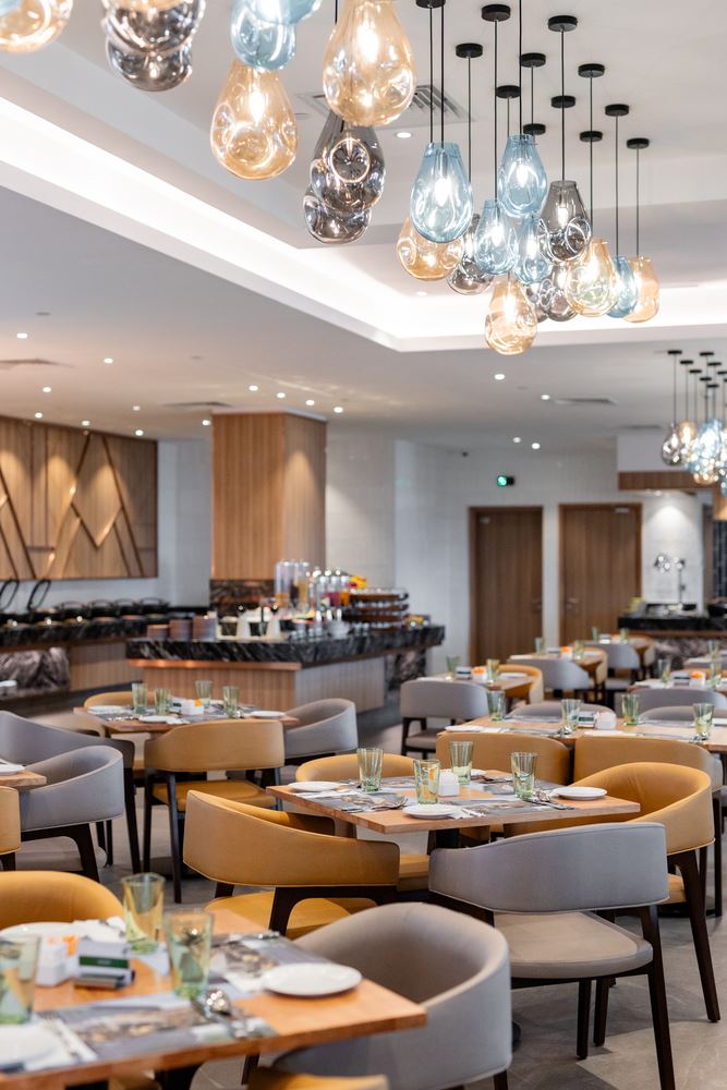 tables and chairs arranged with a chandelier hanging from above