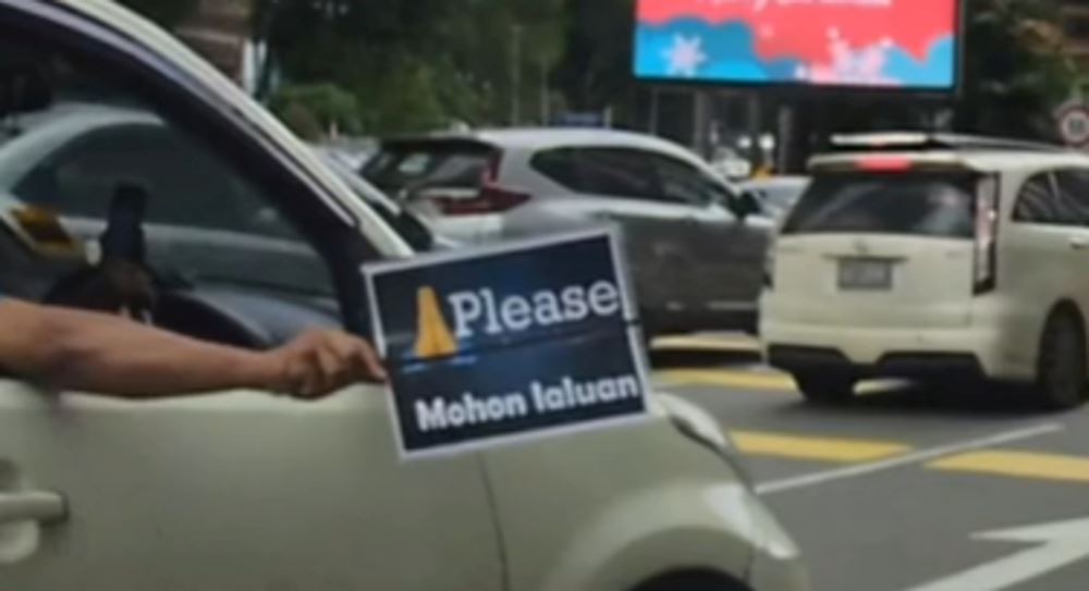 “please, mohon laluan” m’sian driver uses printed sign as signal to change lanes