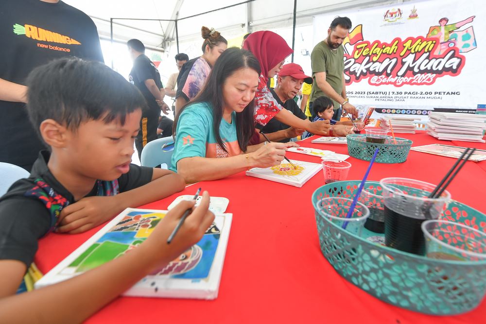 Hannah Yeoh and kids colouring at Rakan Muda event