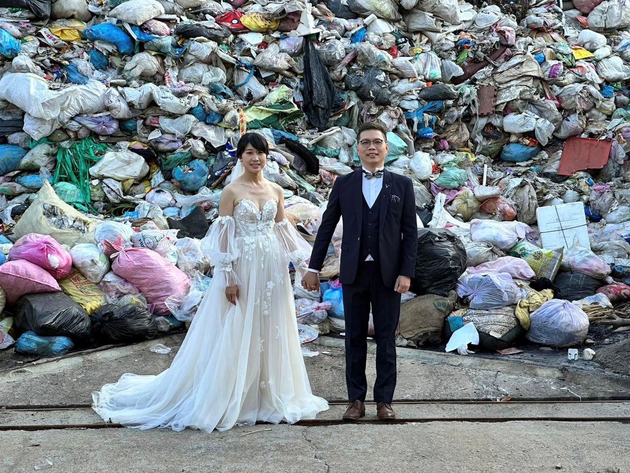 taiwanese couple takes photo in front of trash dump to raise awareness of waste reduction!