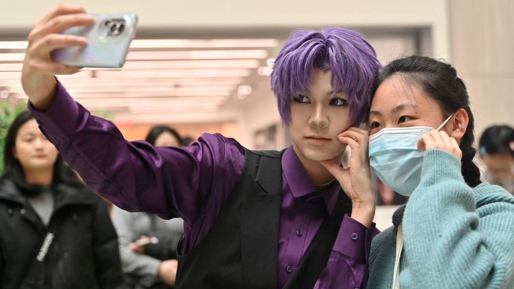 身着特制服装的coser正在和玩家合影。